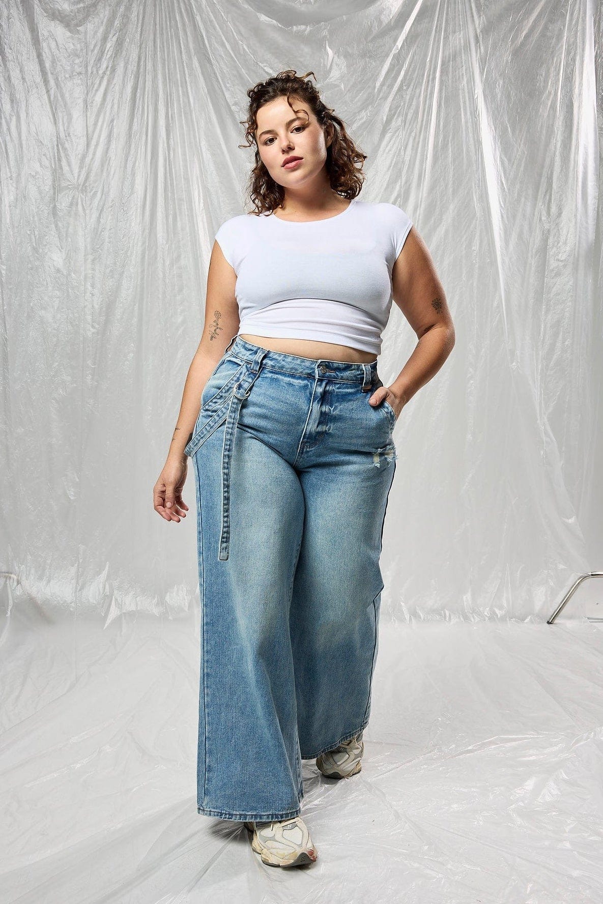 Front view of the model in oversized buckle detail jeans.