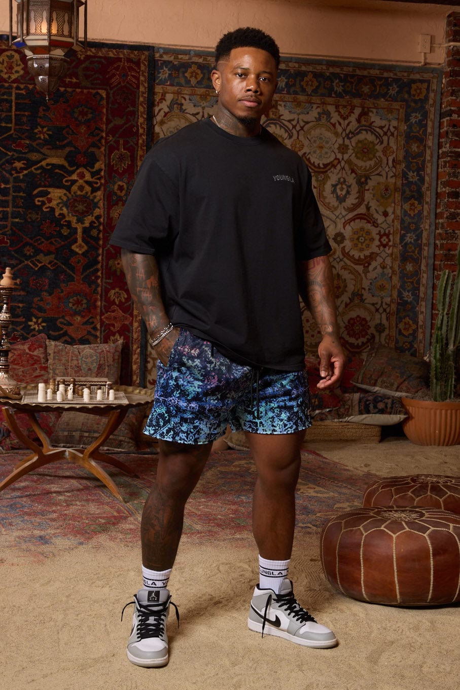 Front view of Persian rug mesh shorts in a natural setting.