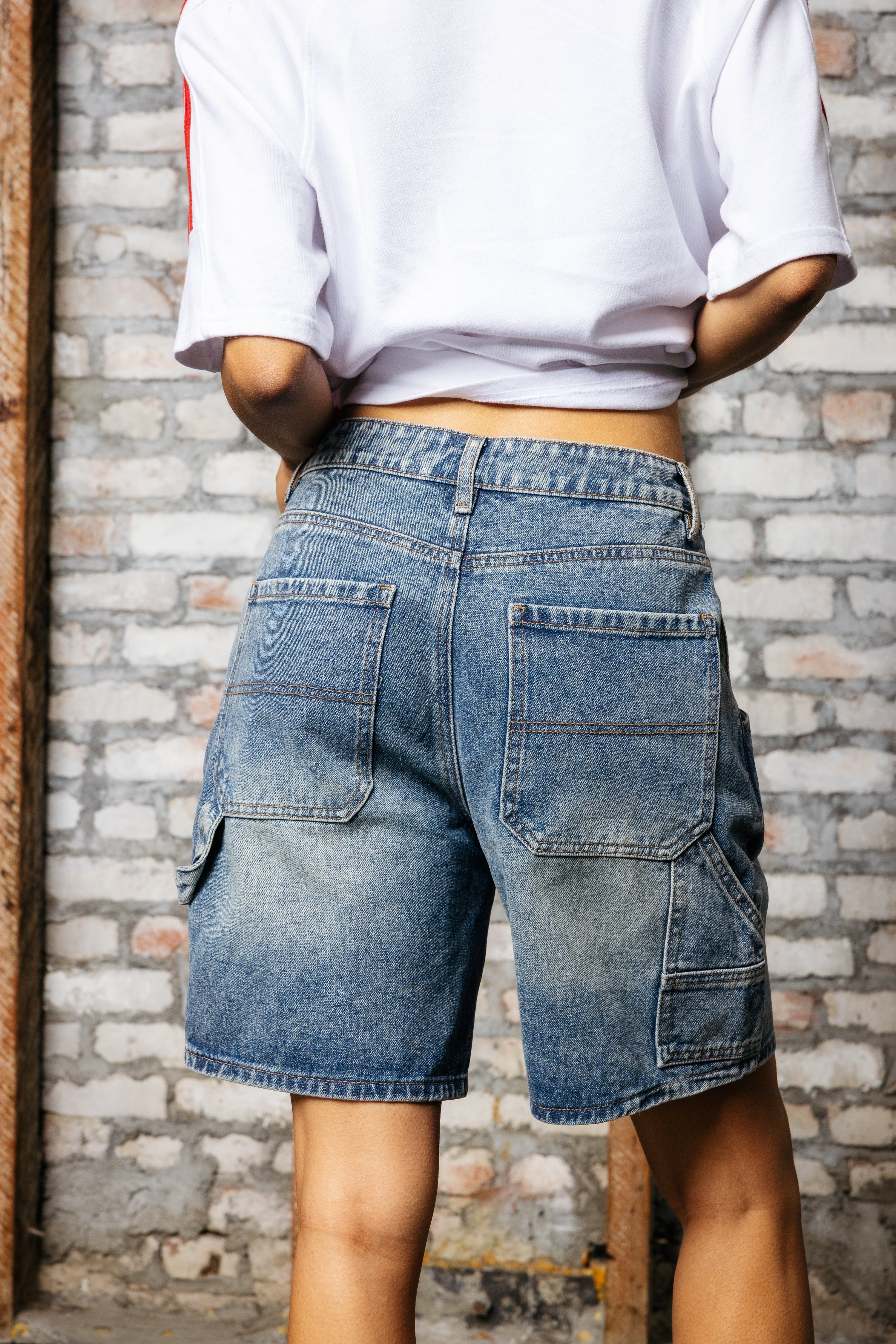 Close-up of dark blue carpenter shorts with deep utility pockets and stitching details.