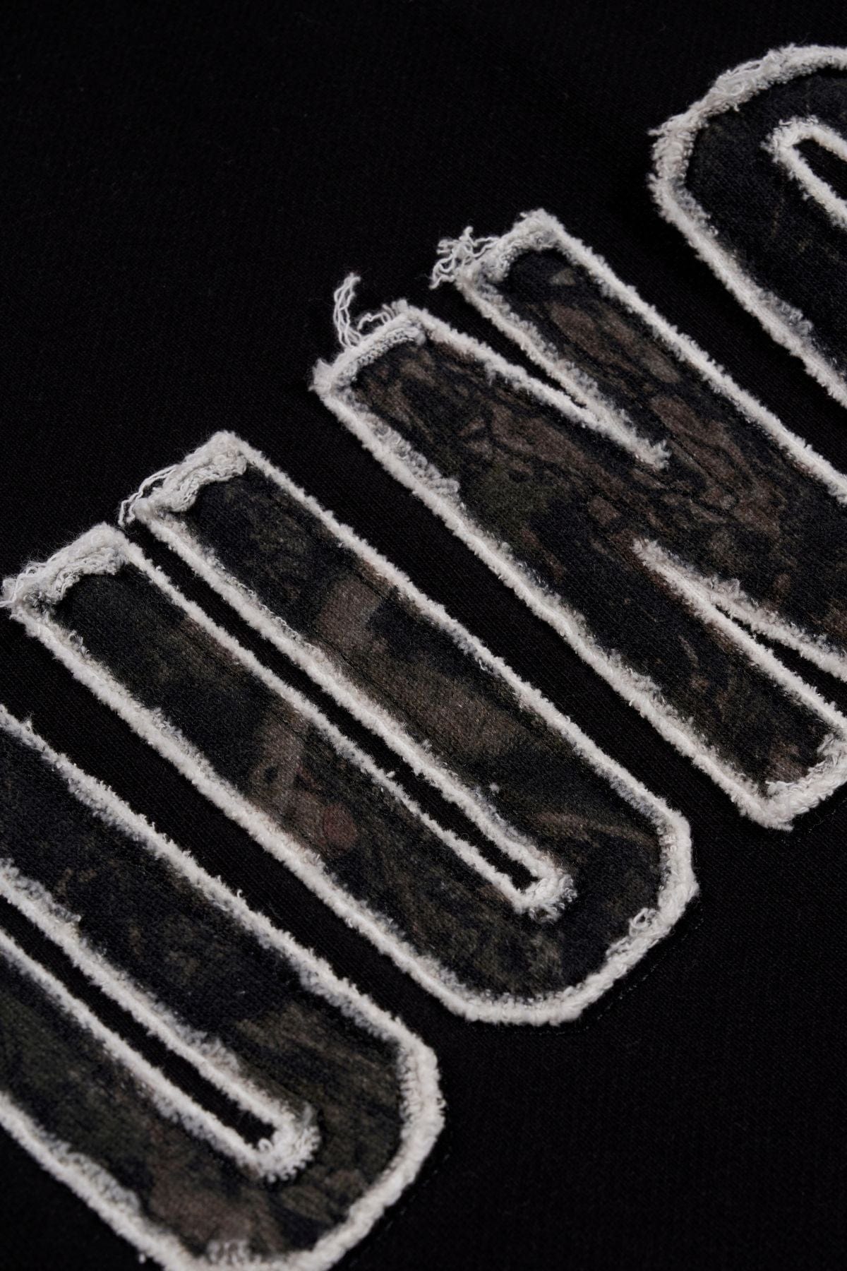 Close-up of the collegiate logo on the oversized hoodie.