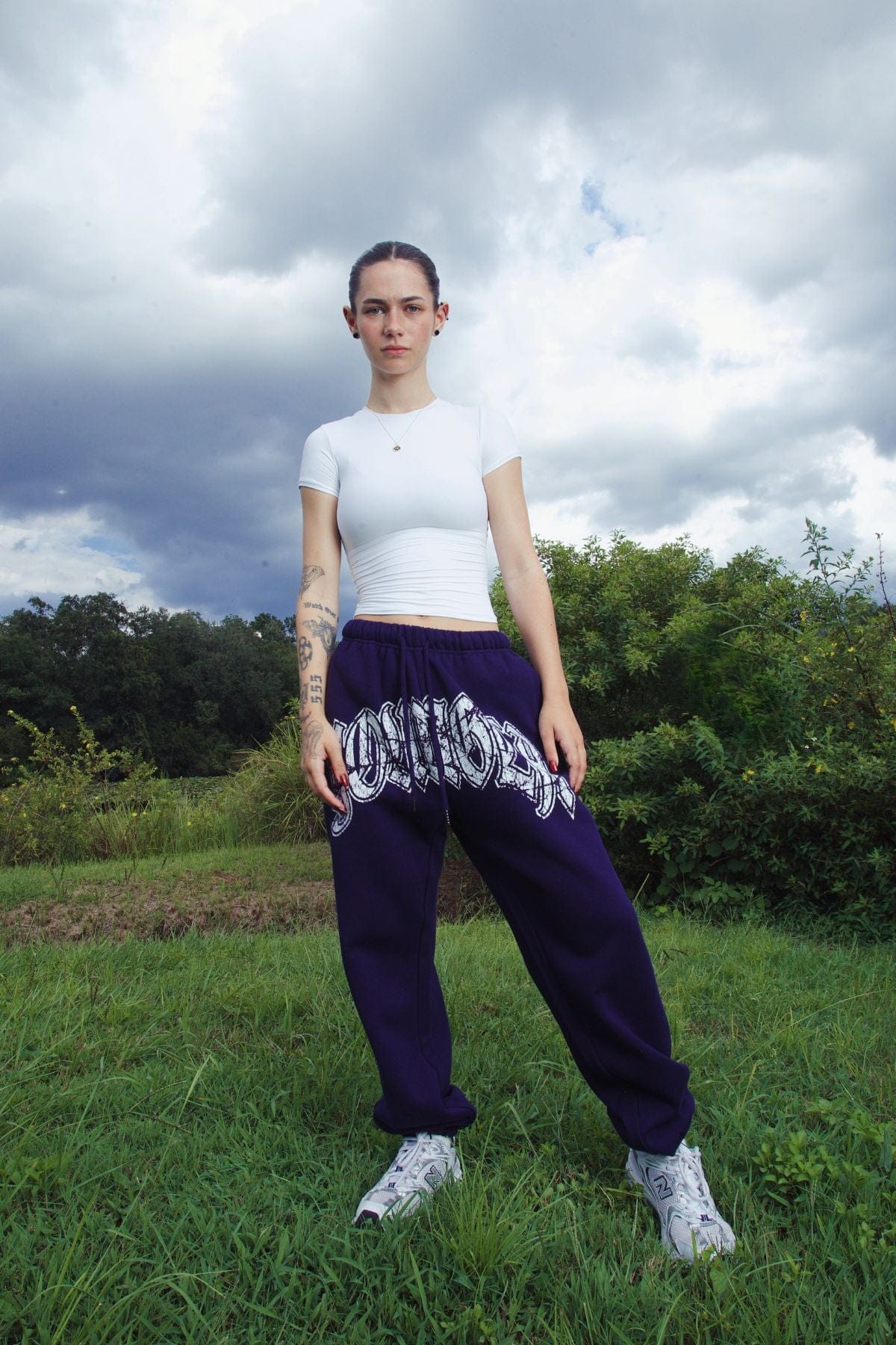 Front view of stylish black joggers for women with a cracked print logo.