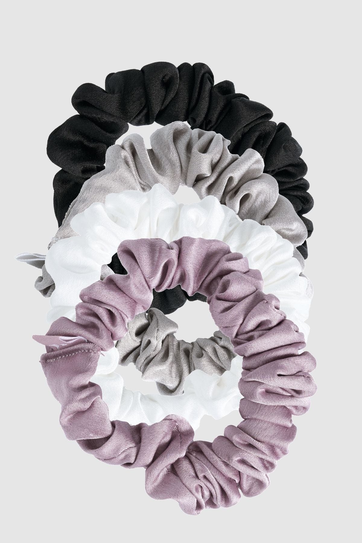 Satin scrunchies worn on a wrist, highlighting their versatility as stylish accessories.