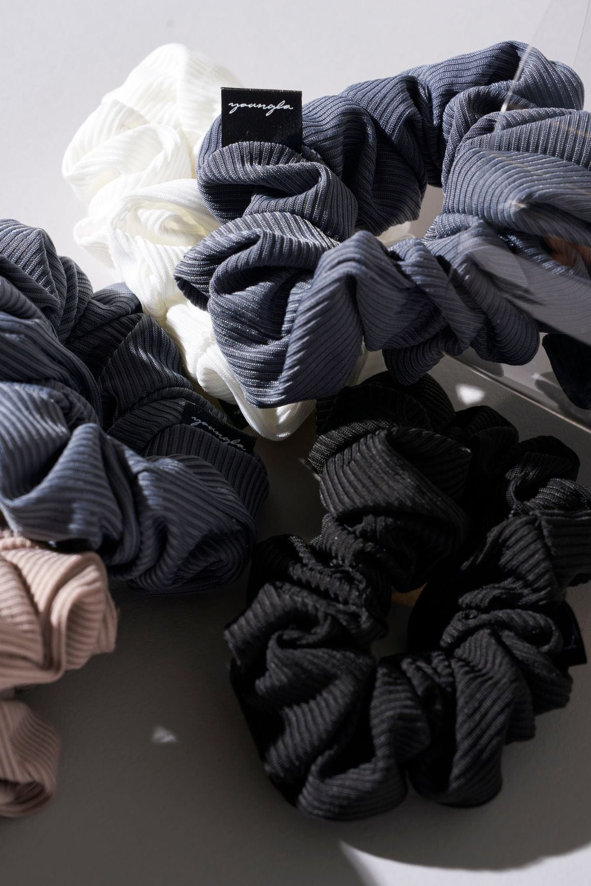 Close-up of ribbed silk scrunchies on a wrist, highlighting their elegant design.