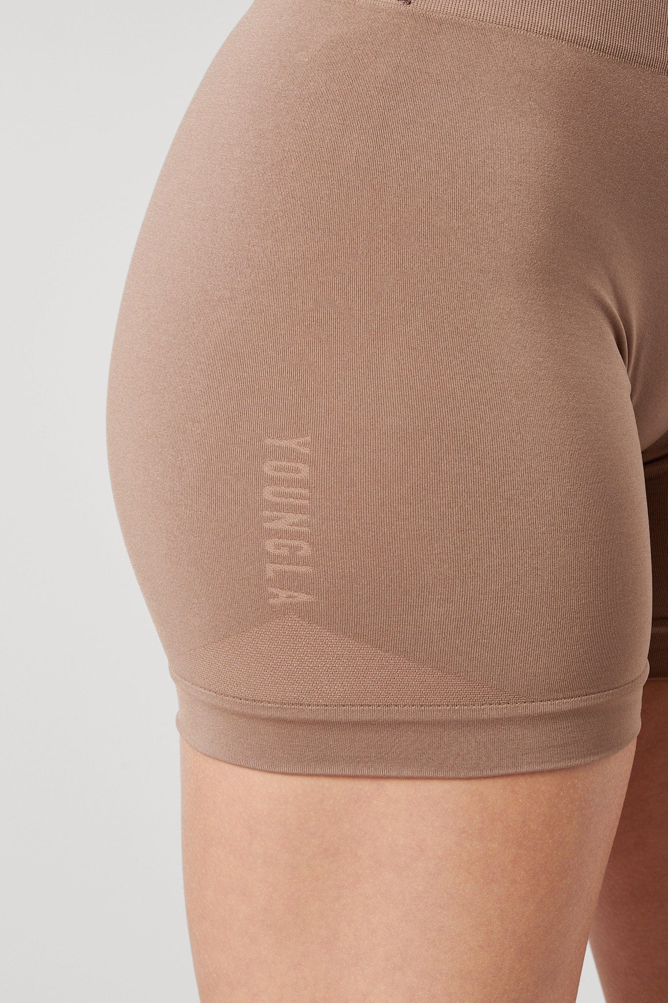 Close-up of the gentle waistband and back scrunch seam of the shorts.
