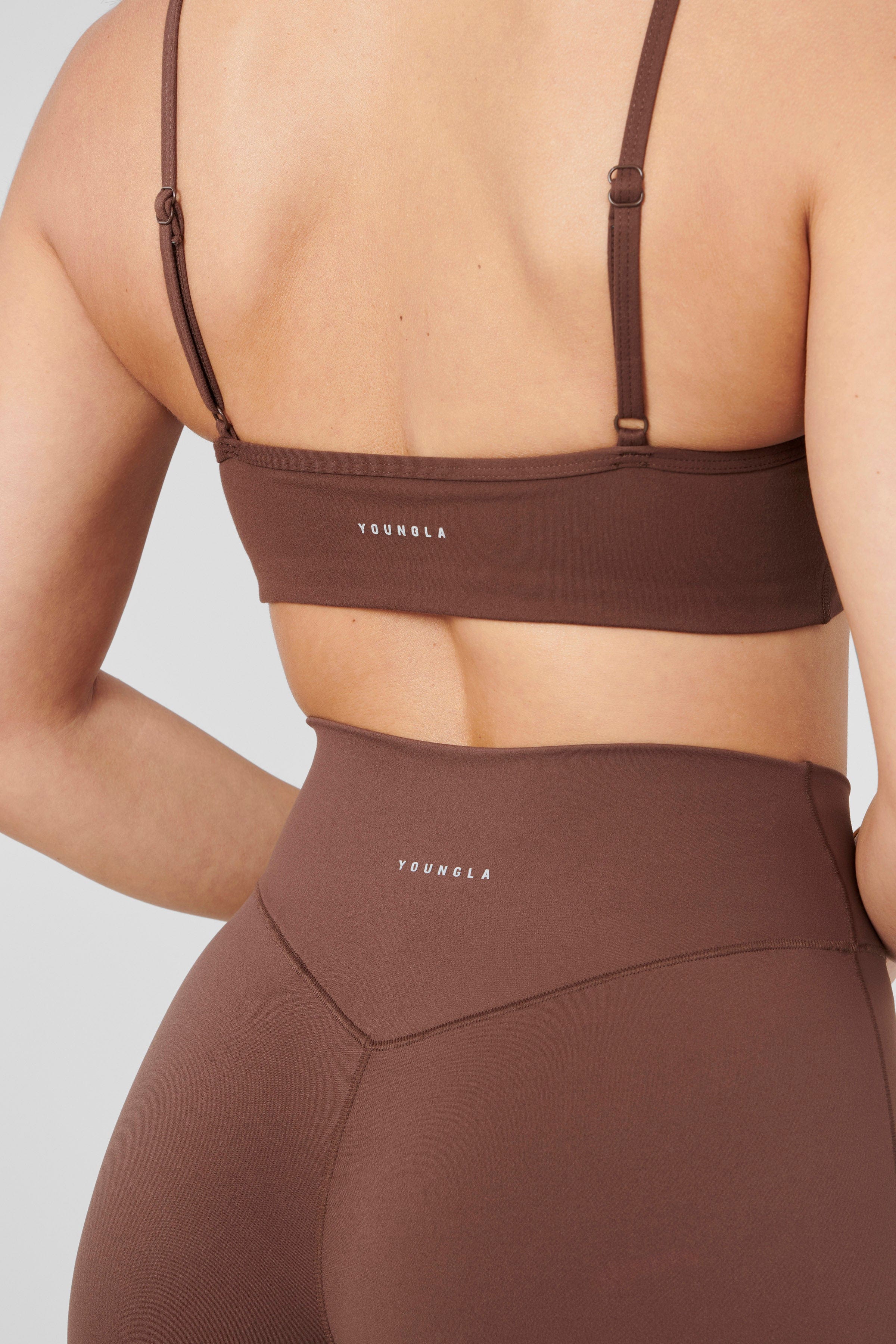 Side view of a model in the Vital Performance Sports Bra paired with Vital Flare leggings.