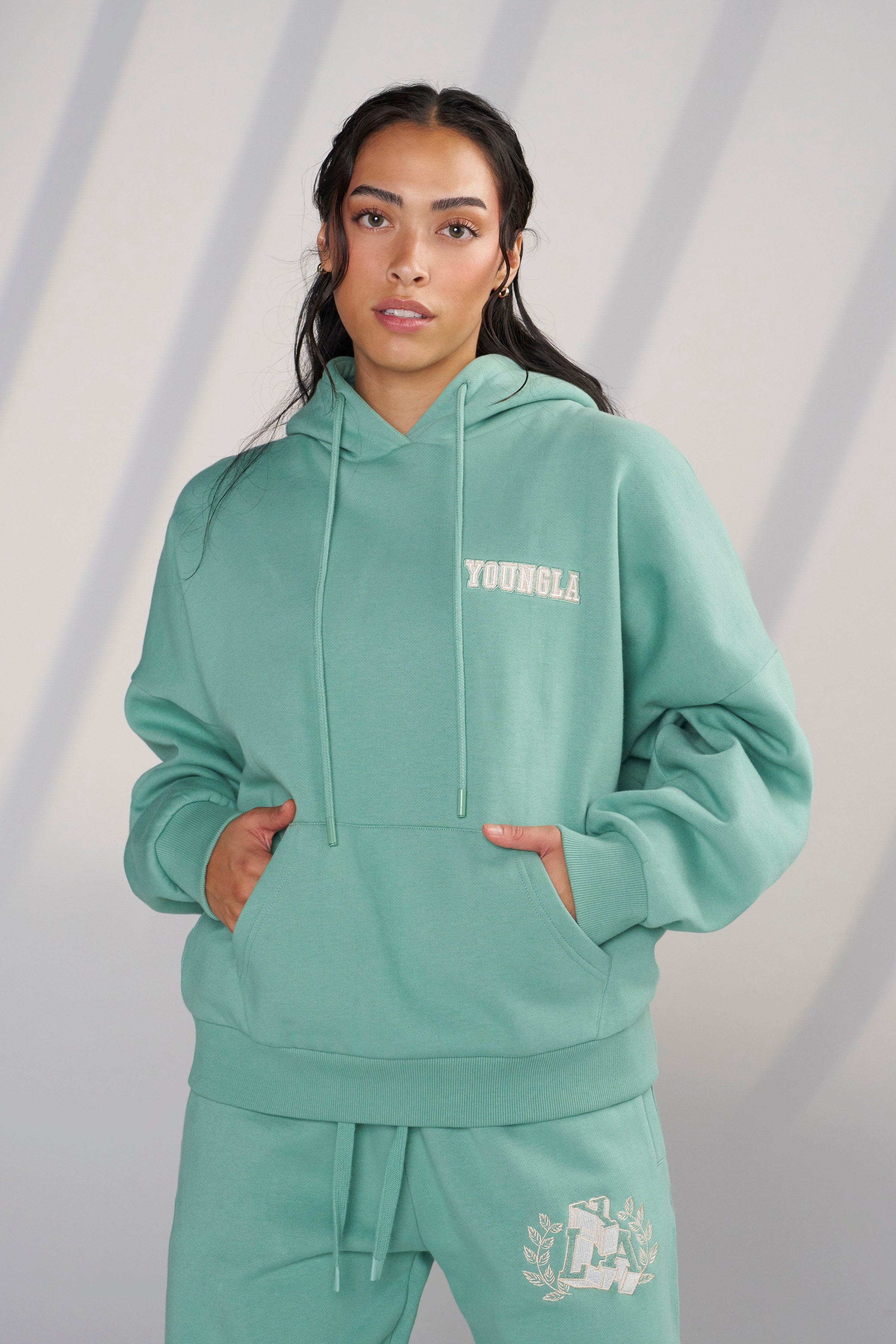Side view showing the plush chenille patch detail on the hoodie.