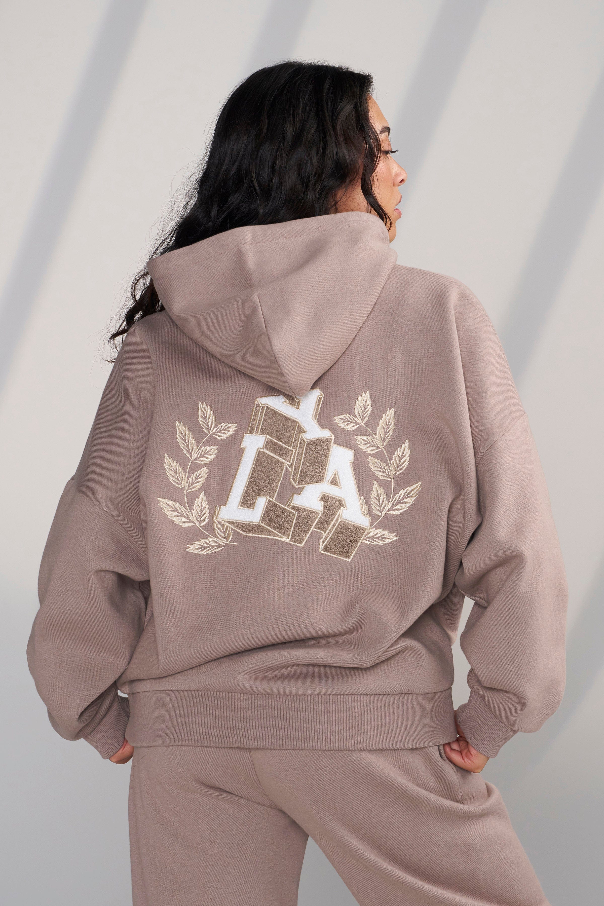 Side view showing the plush chenille patch detail on the hoodie.